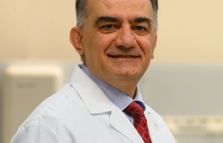 Middle-aged male doctor in a white coat smiling.