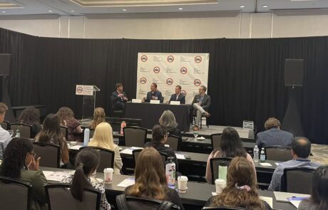 Audience listens to a panel discussion at a conference.