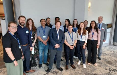 A group of professionals posing for a photo at a conference.