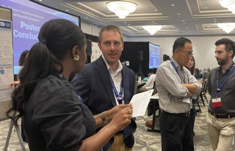 Three people engaged in conversation at a professional event.