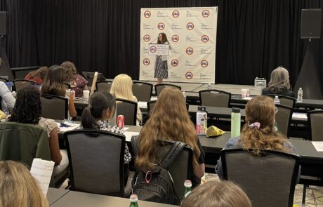 Woman speaking at a conference in front of an audience.